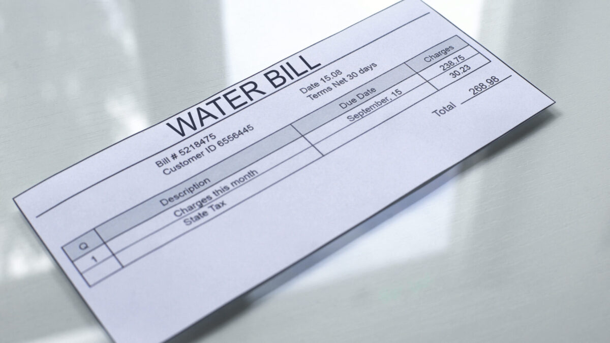 Water bill lying on table, payment for services, month expenses, tariff close up